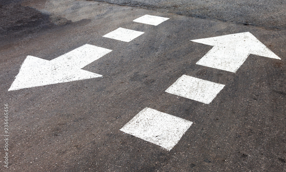 Fototapeta premium Traffic sign white arrows on asphalt road