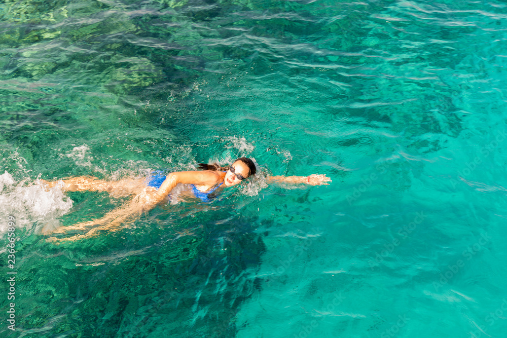 Woman swimmer swimming crawl in blue sea. Woman swiming in the sea