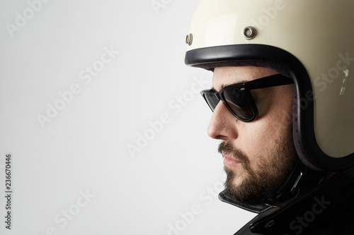 Close up portrait of motorcyclist wearing helmet and leather jacket. Space for your text.