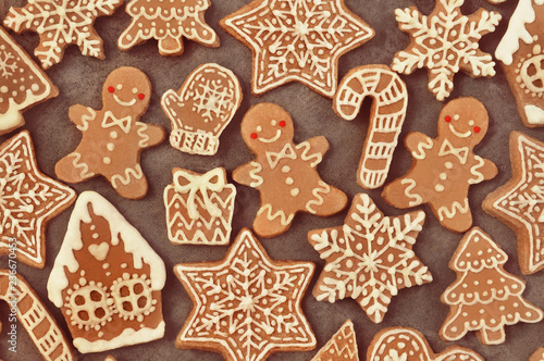 Homemade gingerbread house and gingerbread man cookies, festive Christmas and New Year sweeties background card, toned