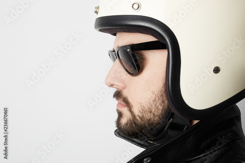 Close up portrait of motorcyclist wearing white helmet and leather jacket. Space for your text.