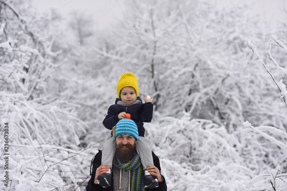 Snowballs. Game with father. Outdoor walk of happy father and son smiling. Young man and little boy, snowball in child hand and enjoying to winter walk together. December holidays. Merry Christmas Snowballs. Game with father. Outdoor walk of happy father and son smiling. Young man and little boy, snowball in child hand and enjoying to winter walk together. December holidays. Merry Christmas