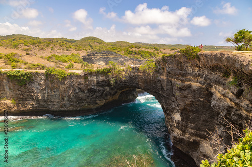 Stone arch over the sea. Beautiful and clear turquoise water at Broken Beach in Nusa Penida, Indonesia.
