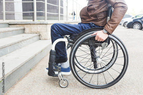 Man in wheelchair in front of stairs.