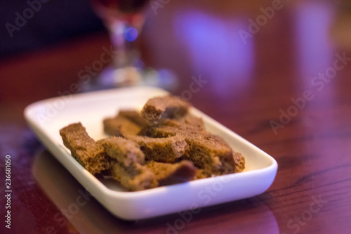 Rectangular white plate with a beer snack with rye flour crackers. photo