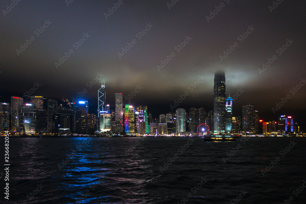 Obraz premium Night view of Hong Kong Central skyline with the top of skyscrapers surrounded by clouds and mist
