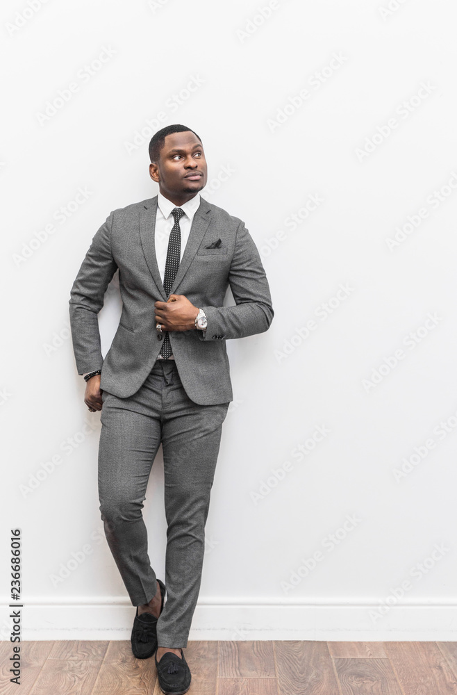 Young African American businessman in a gray suit on a white background. Young African American businessman in a gray suit on a white background.