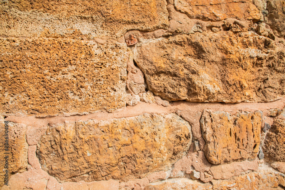 Fototapeta premium Old beige stone wall background texture close up