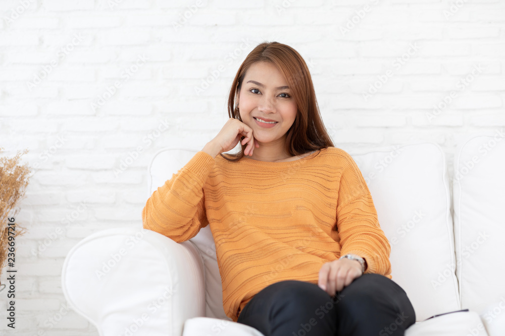 Beautiful Attractive Asian woman sitting on white sofa smile and relax in living room feeling so comfortable and happiness in holidays,Lifestyle Concept Beautiful Attractive Asian woman sitting on white sofa smile and relax in living room feeling so comfortable and happiness in holidays,Lifestyle Concept