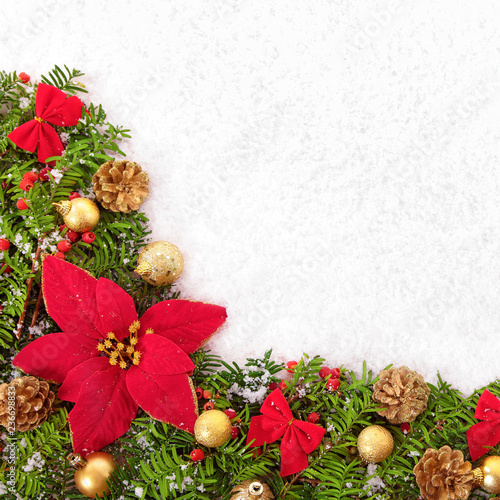 Christmas border with traditional decorationsand poinsettia on the snow square photo