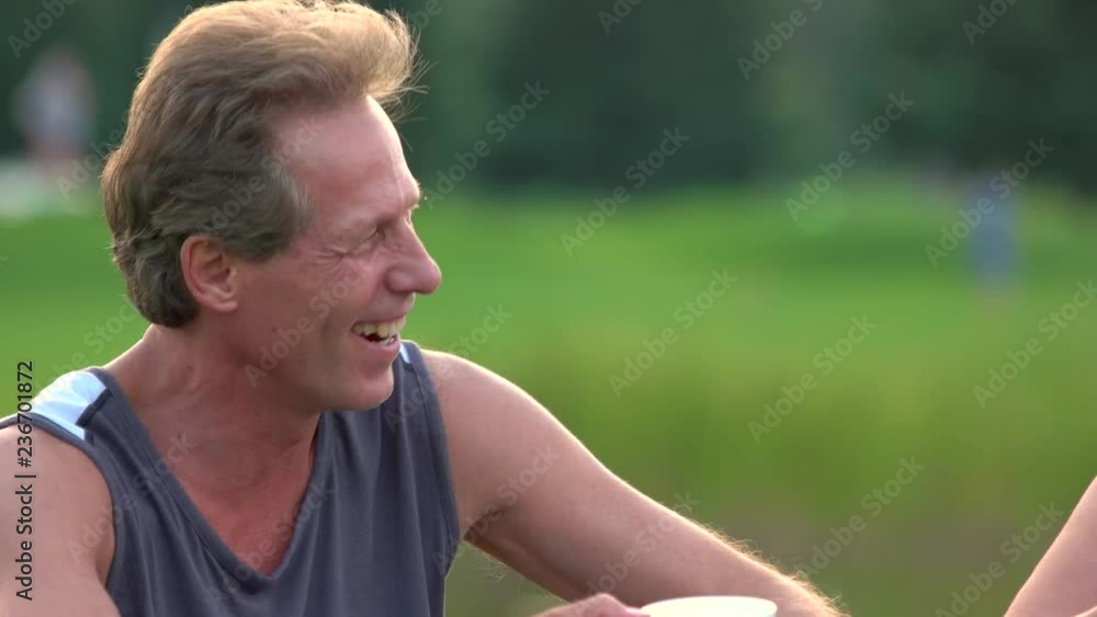 Laughing mature man holding tea cup outdoors. Happy weekend with friends in summer park. Relax for mind and body. Human facial expressions of joy. Laughing mature man holding tea cup outdoors. Happy weekend with friends in summer park. Relax for mind and body. Human facial expressions of joy.