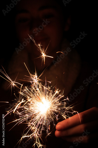 Mujer joven con luces de bengala durante una noche de celebración