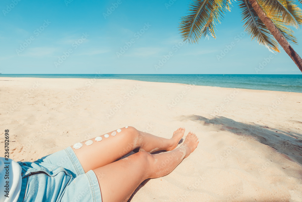 Relaxation and Leisure in summer - Seashell on tanned girl leg sunbathe at tropical beach in summer. vintage color tone Relaxation and Leisure in summer - Seashell on tanned girl leg sunbathe at tropical beach in summer. vintage color tone