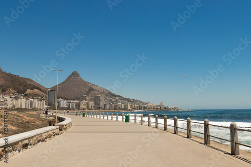 Mountains, hotels and deep blue water with waves at the Sea Point, beach promenade in Cape Town South Africa.