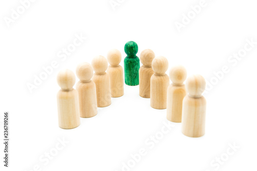 Fotografie Green figure leading group of wooden figures in spearhead formation, isolated on