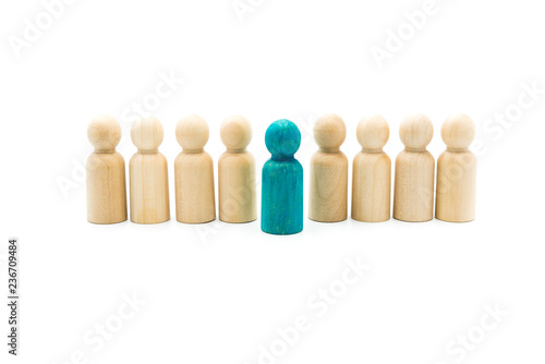 Wooden figures in line as business team, with one blue figure standing out from the crowd, isolated on white background