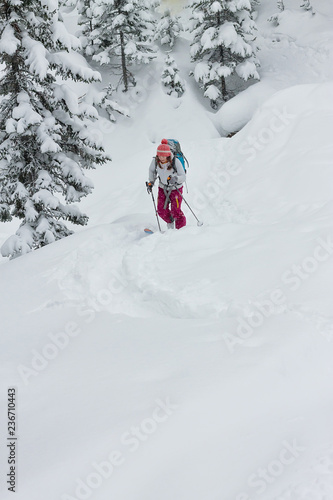 Woman skier freerider skitur uphill in snow in winter forest