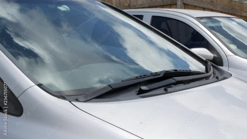 Man discovers a parking ticket under the window wipers of his car. Pulls out the ticket and shakes it in anger. Man discovers a parking ticket under the window wipers of his car. Pulls out the ticket and shakes it in anger.