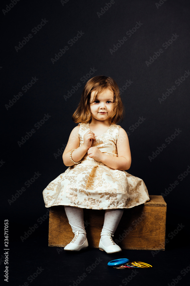 Portrait of a small toddler girl isolated on black studio background Portrait of a small toddler girl isolated on black studio background