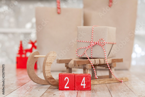 24 december date on wooden red blocks with brown sleigh and presents photo