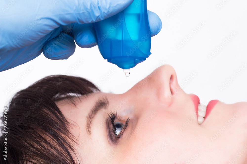 doctor buries moisturizing and vasoconstrictor eye drops to a caucasian