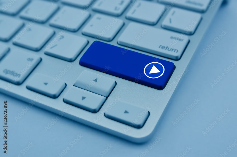 Play button flat icon on modern computer keyboard button, blue tone, Business music online concept Play button flat icon on modern computer keyboard button, blue tone, Business music online concept