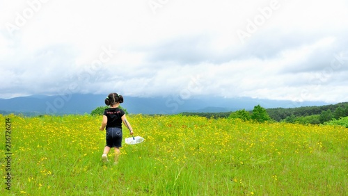 花の草原で遊ぶ少女