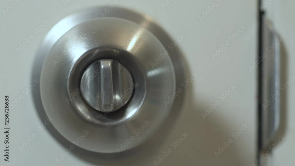 Close up on a Hand twisting the lock mechanism to unlock and lock a privacy doorknob. Opening and closing the door. Close up on a Hand twisting the lock mechanism to unlock and lock a privacy doorknob. Opening and closing the door.