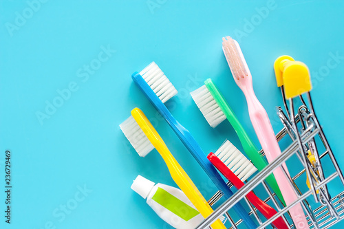 Shopping cart with toothbrush and toothpaste on blue background for market and dental care concept