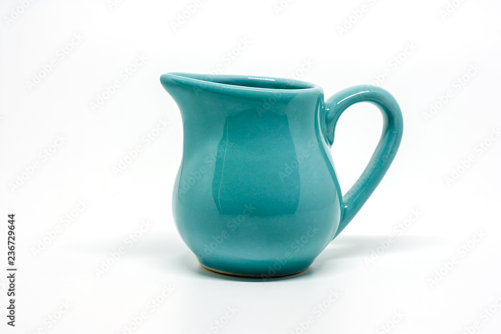 Green small ceramic pitcher on white background for utensil and dishware concept Green small ceramic pitcher on white background for utensil and dishware concept