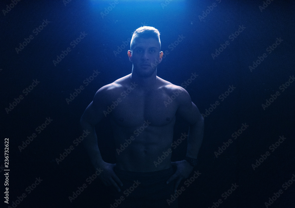 Shirtless Caucasian muscular man posing with hands on hips. Don't wish for a good body, work for it.