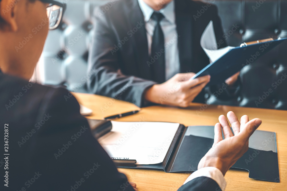 Senior manager reading a resume during a job interview employee young man meeting Applicant and recruitment concept Senior manager reading a resume during a job interview employee young man meeting Applicant and recruitment concept