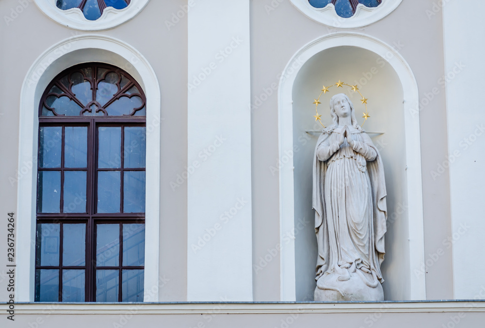 The statue above the entrance to the church Merciful Brothers in Pecs The statue above the entrance to the church Merciful Brothers in Pecs