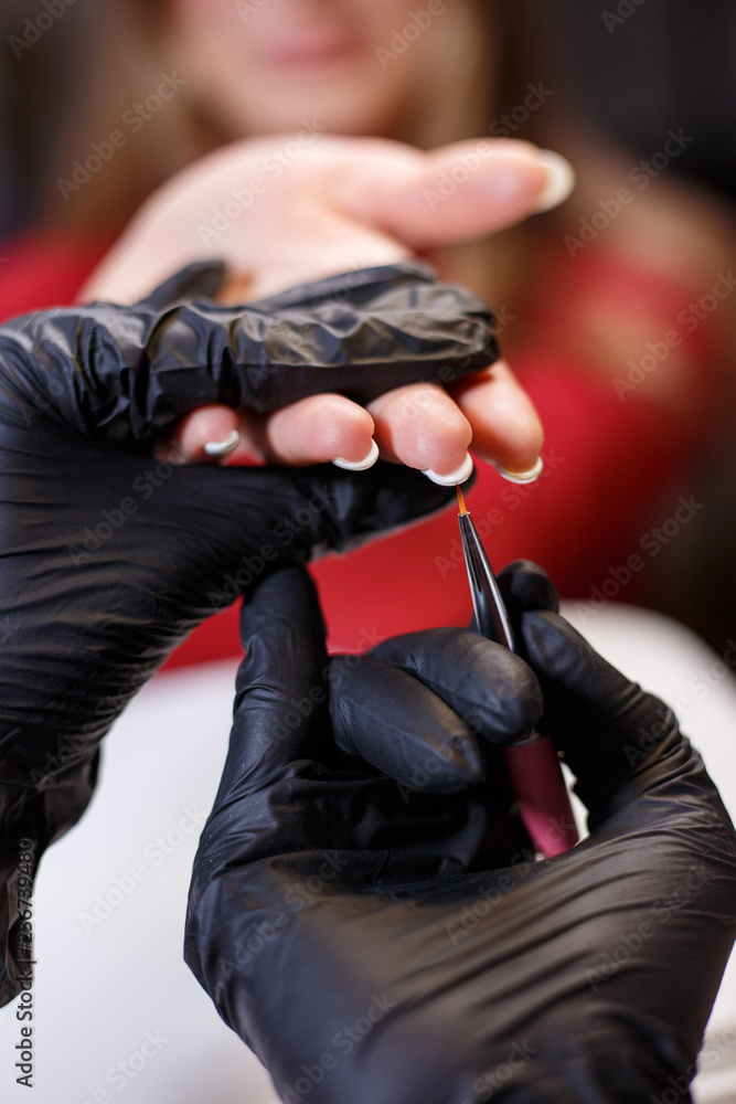 Fototapeta premium manicurist applying gel lacquer coat on client's nails. beauty, make up, manicure, nail art concept