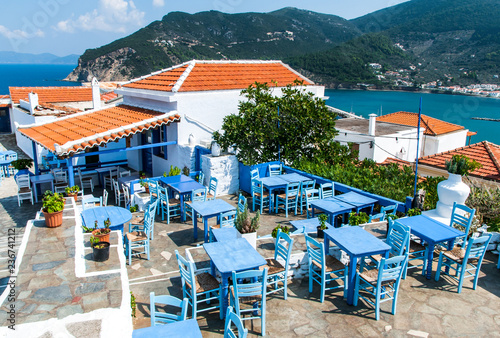 An old restaurant on hill in Skopelos town with outdoor seats from woodware blue painted furnitures and sea views