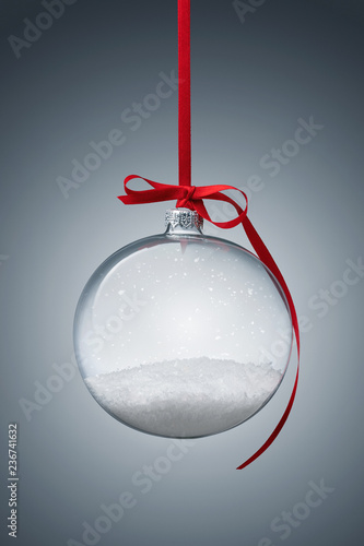 Empty transparent christmas ball over gray background with copy space