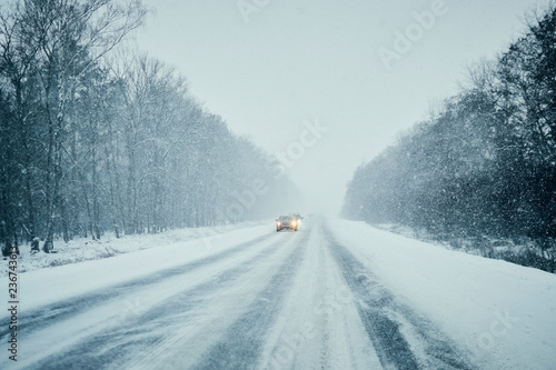 Car in storm on winter road with traffic. Danger driving in winter. First person view