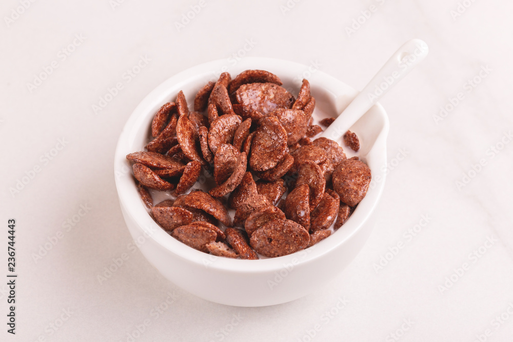 Crunchy chocolate corn flakes in bowl with milk Crunchy chocolate corn flakes in bowl with milk