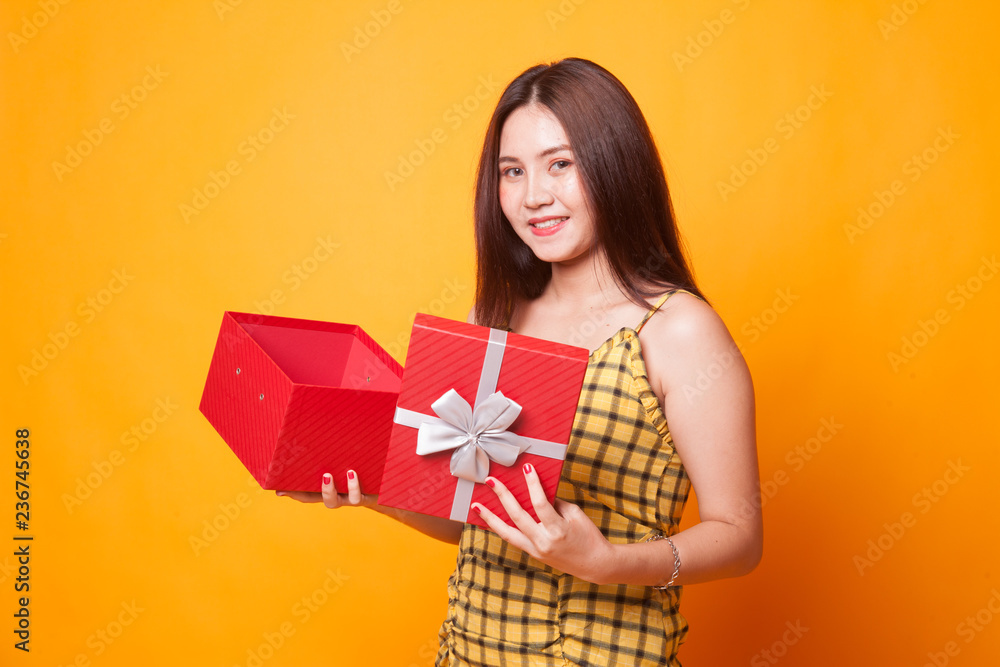 Young Asian woman open a golden gift box. Young Asian woman open a golden gift box.