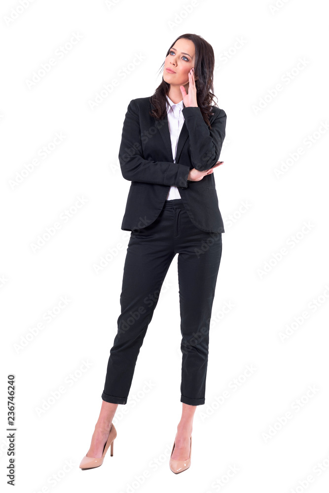 Thoughtful young business woman in suit looking up watching interested at business presentation. Full body isolated on white background. 
