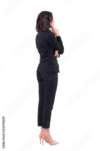Back view of elegant business woman in suit looking away at something watching interested. Full body isolated on white background. 