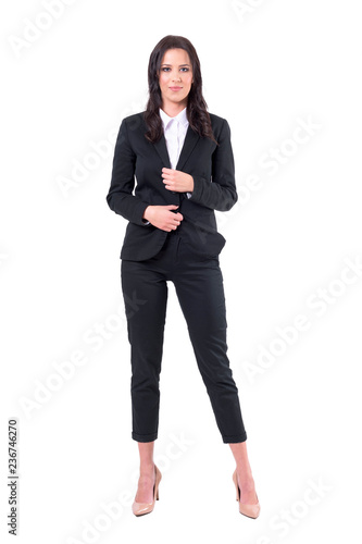 Charming smiling business woman in black suit looking at camera with confident smile. Full body isolated on white background. 