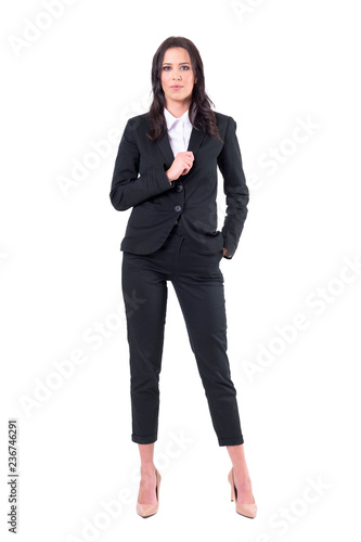 Confident businesswoman in black elegant suit holding collar posing and looking at camera. Full body isolated on white background. 