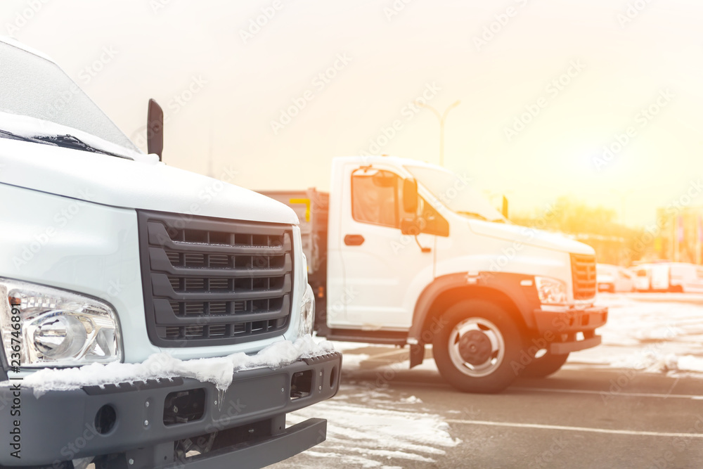 New middle size trucks at dealership parking outdoors at winter. Truck service and maintenance. Delivering and warehouse service New middle size trucks at dealership parking outdoors at winter. Truck service and maintenance. Delivering and warehouse service