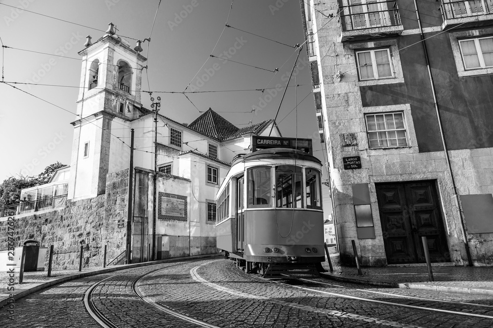 Black and white picture of a tram on the streets of Lisbon, Alfama, Portugal near Santa Luzia church
