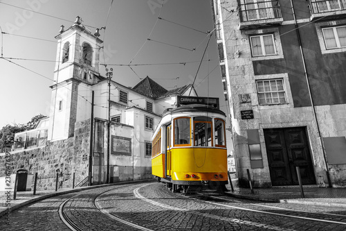 Canvas Print Black and white picture of a yellow tram on the streets of Lisbon, Alfama, Portu