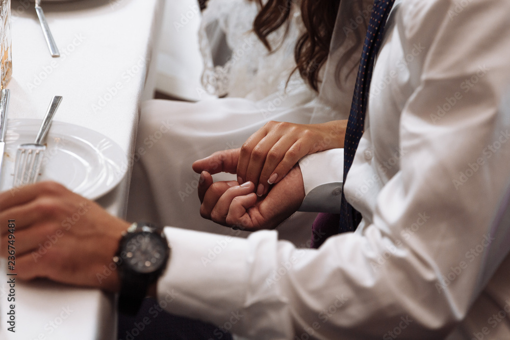 newlyweds hold each other's hands with golden rings