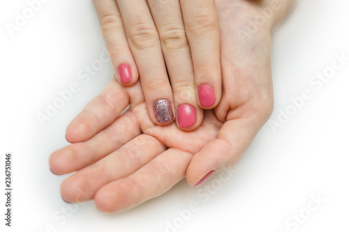 Hands with long artificial manicured nails colored with red nail polish