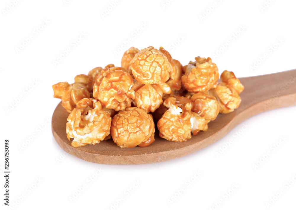 sweet butter caramel popcorn on wooden spoon and on white background sweet butter caramel popcorn on wooden spoon and on white background