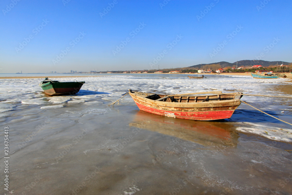 fishing boats, ice and snow by the sea